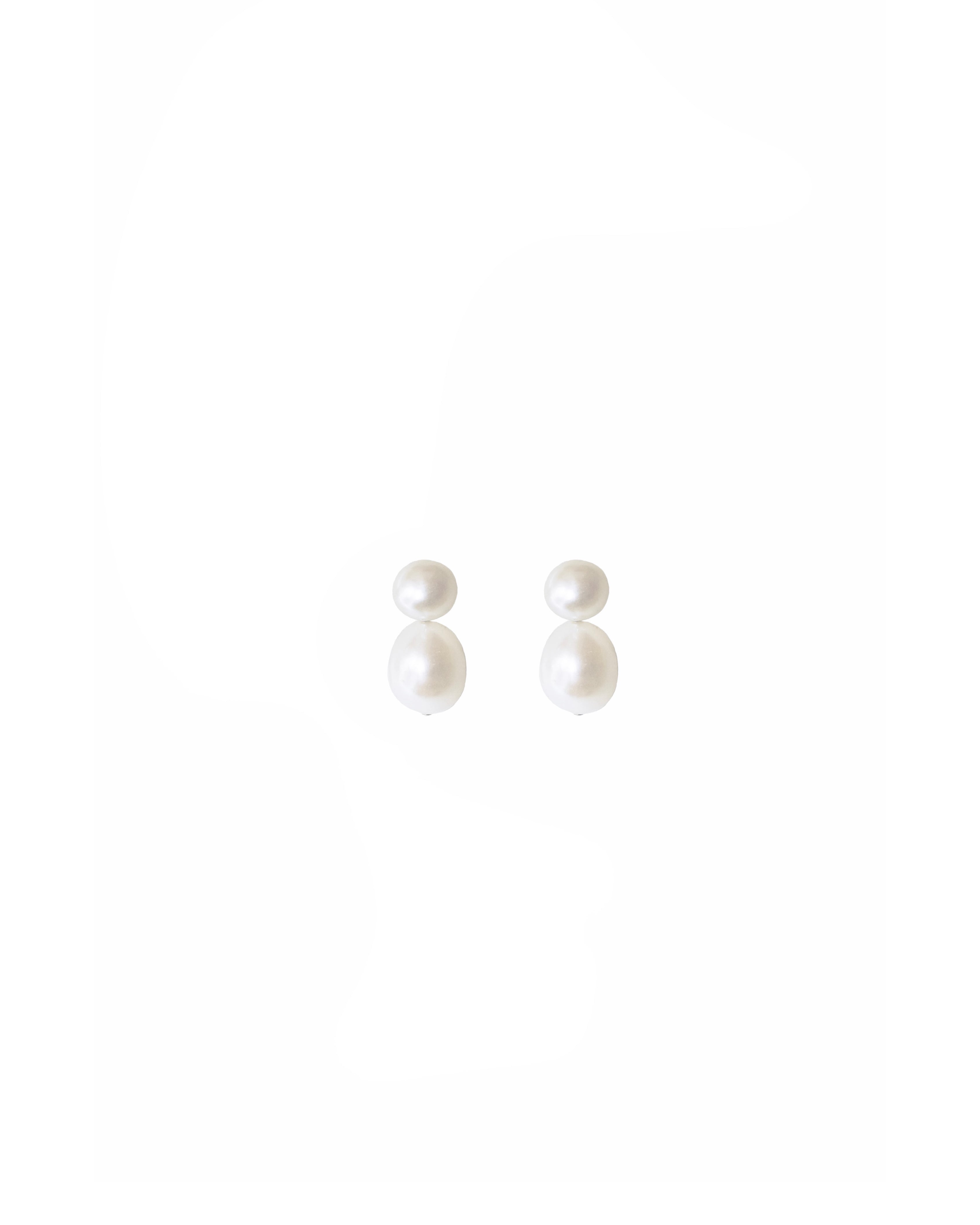 A pair of handmade pearl earrings with a stud and a drop-shaped freshwater pearl suspended below.