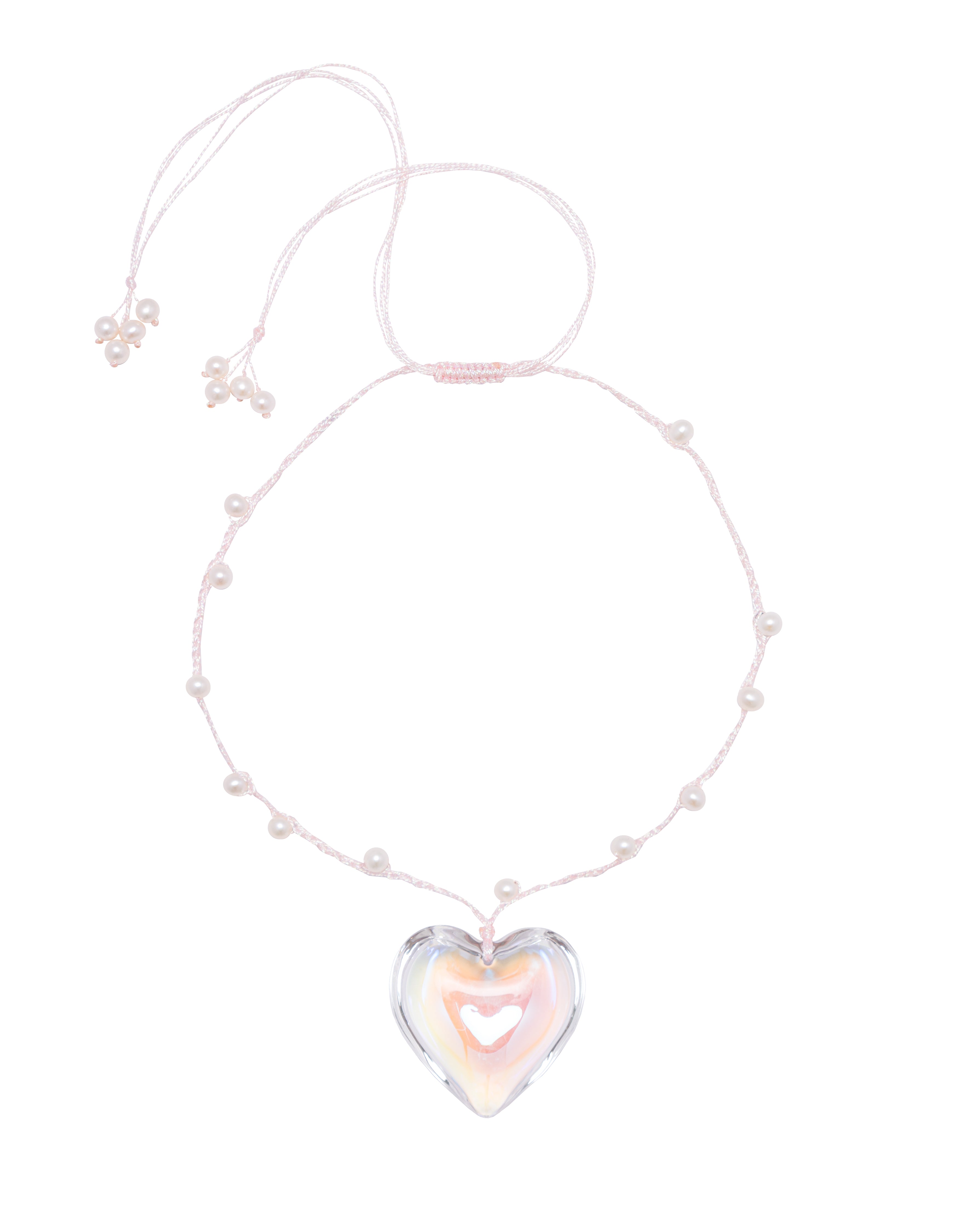 A baby pink necklace with a glass heart pendant and freshwater pearl beads threaded on a polyester thread.
